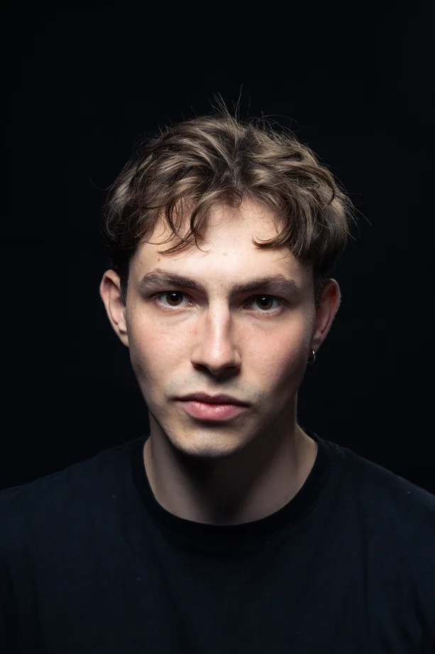 Čelní studiový portrét muže v černém tričku