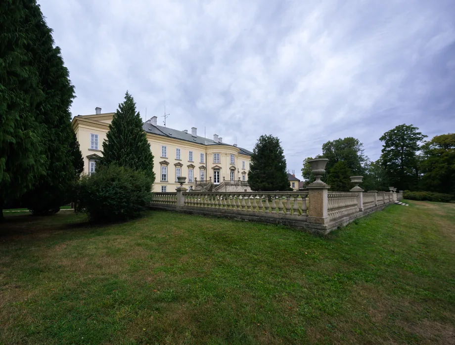 Zámecká budova s parkem a kamennou balustrádou