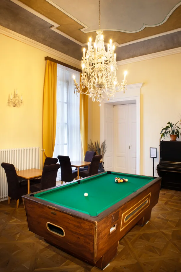 Žlutý salon s lustrem a kulečníkovým stolem